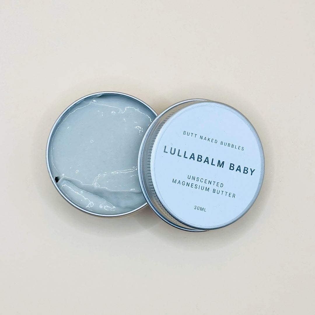 Lullabalm Baby tin with lid open on a beige background