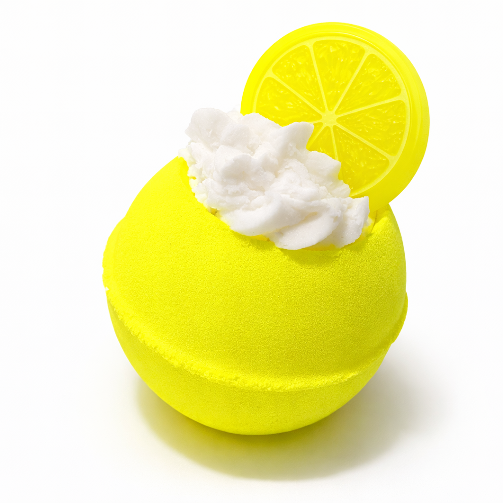 Yellow bath bomb with white whipped bubble bath topping and a lemon slice shaped soap on top, on a white background.